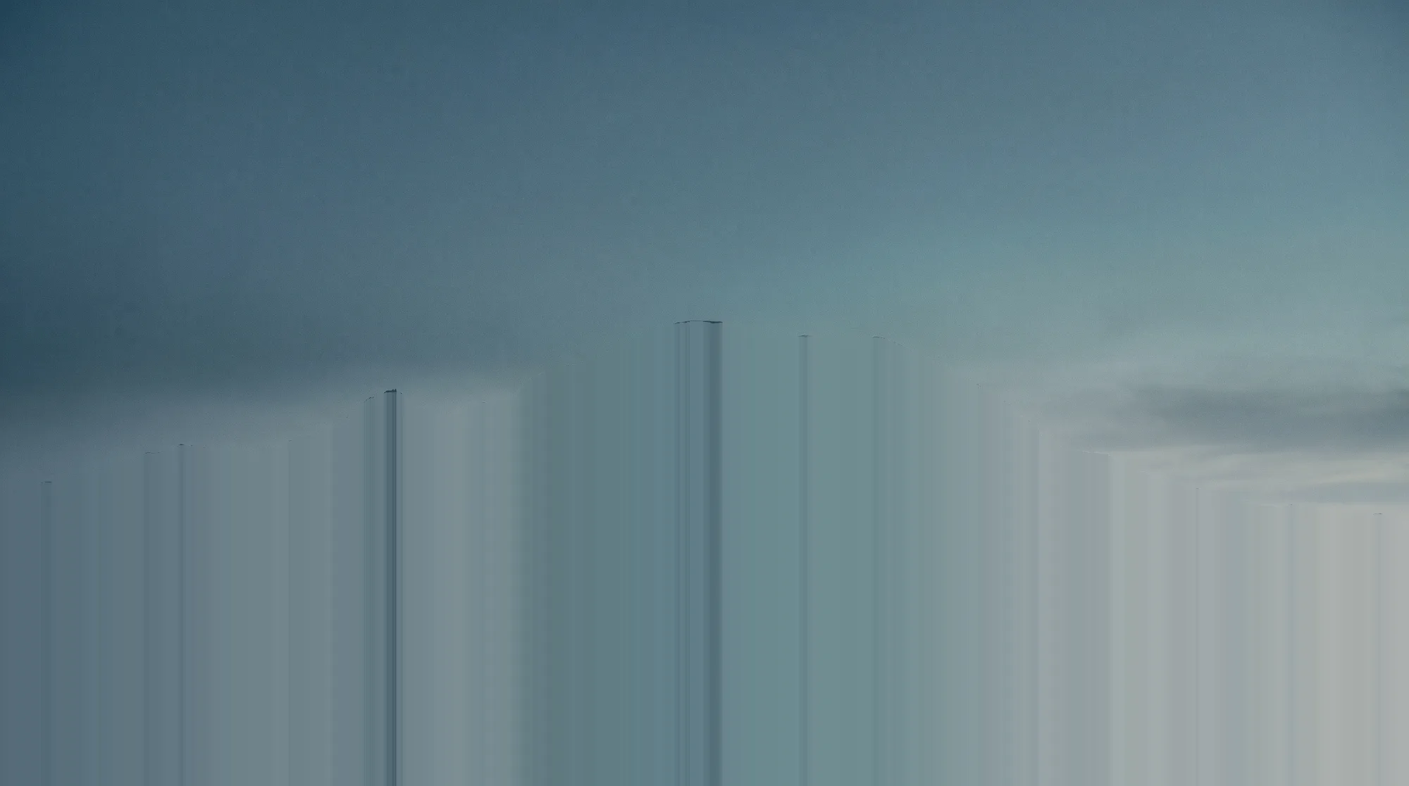 A great snow-capped mountain under a still blue-hour sky.