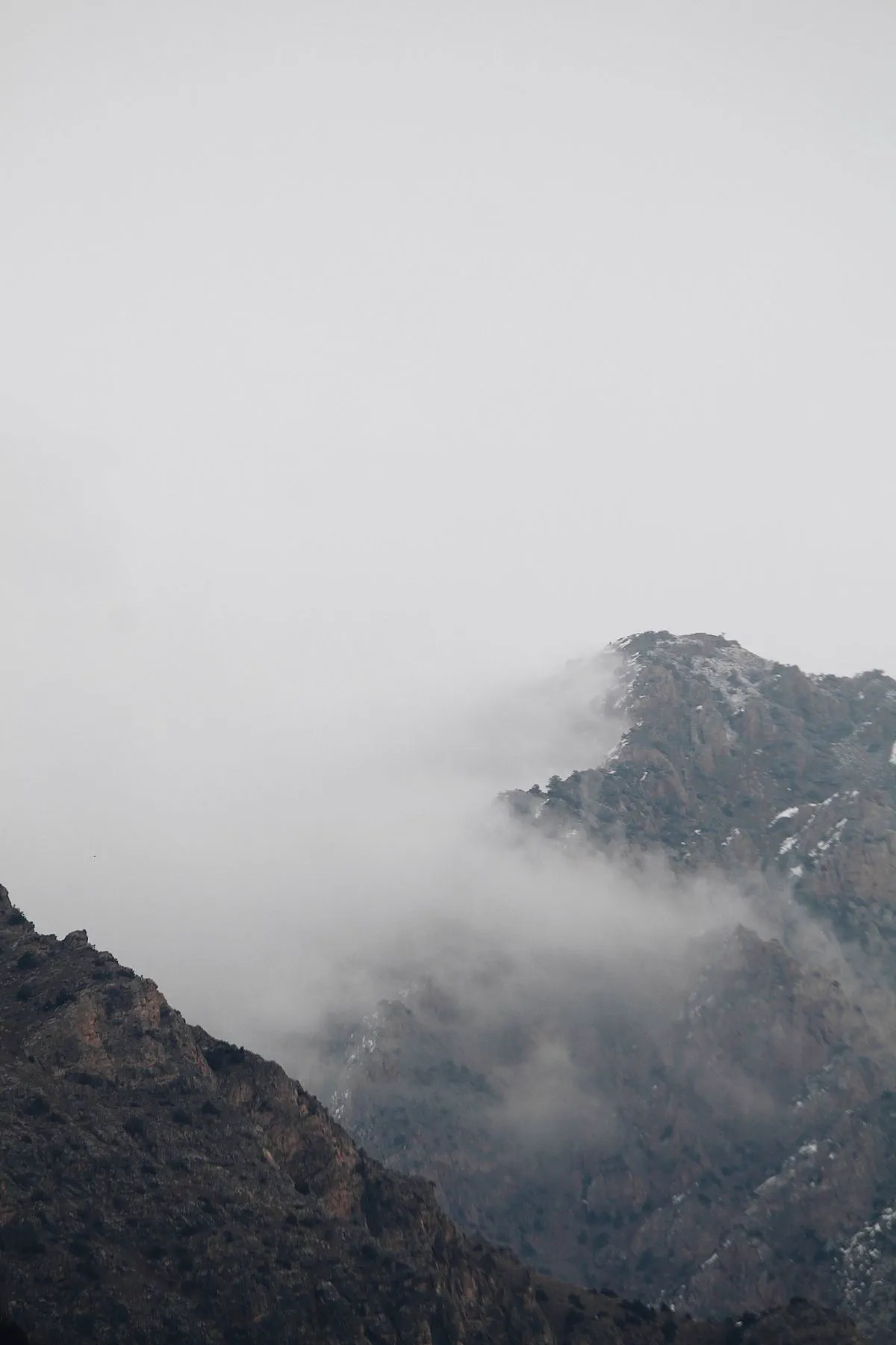 A rocky summit emerging from mist and cloud.